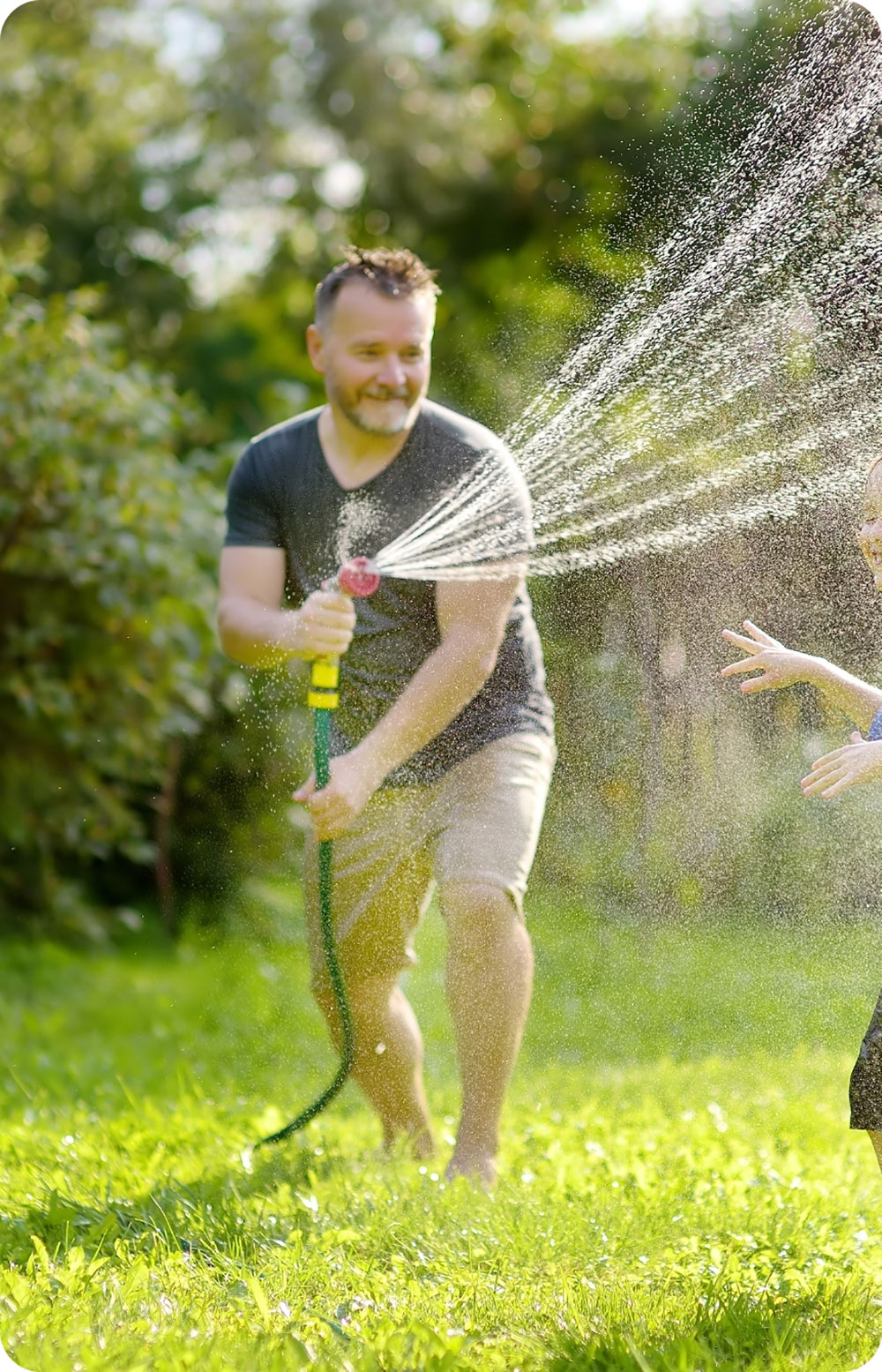 Father son playing in lawn with water